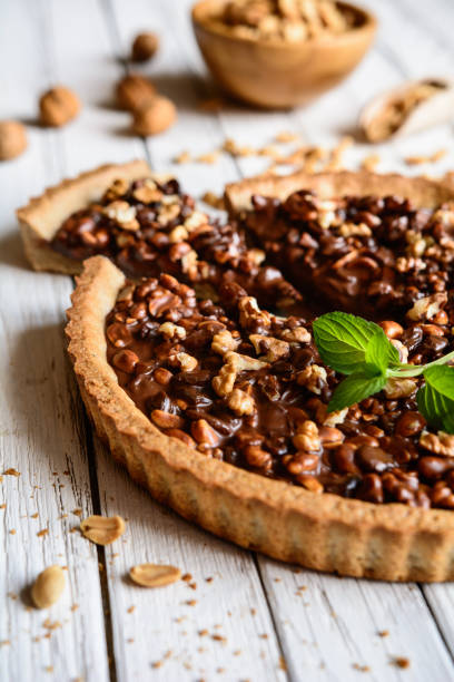 Tarte au pralin craquant, ganache au chocolat noir, caramel et fruits secs (8 parts)